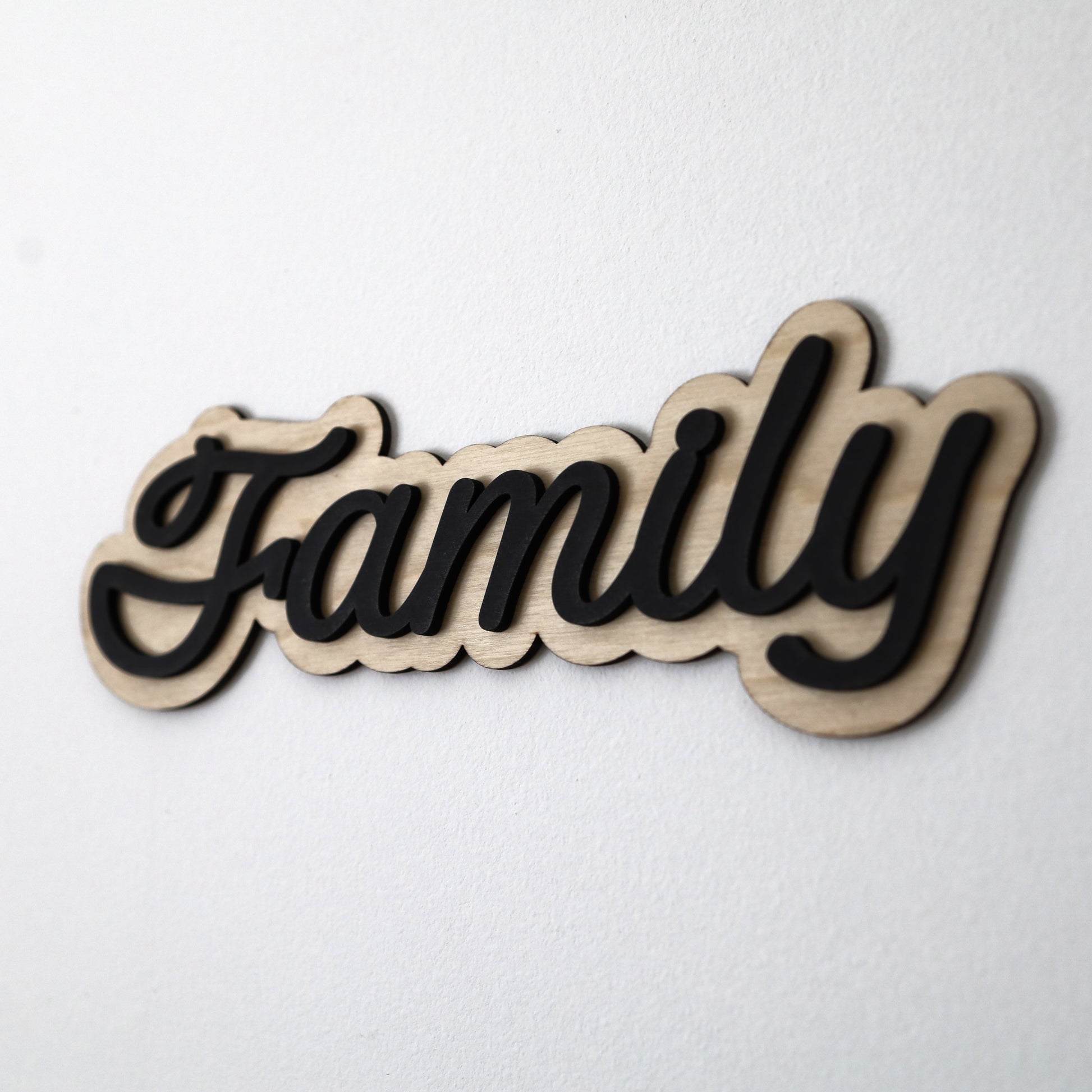 Modern family sign with black wood accents, layered design, and easy adhesive installation, perfect for adding warmth to your home décor.