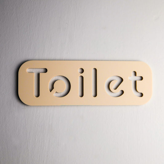 Modern self-adhesive toilet sign with minimalist design on a bathroom door.