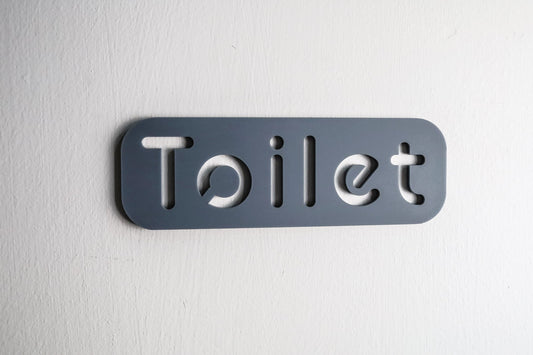 Modern grey toilet door sign with sleek cut-out typography on high-quality acrylic.