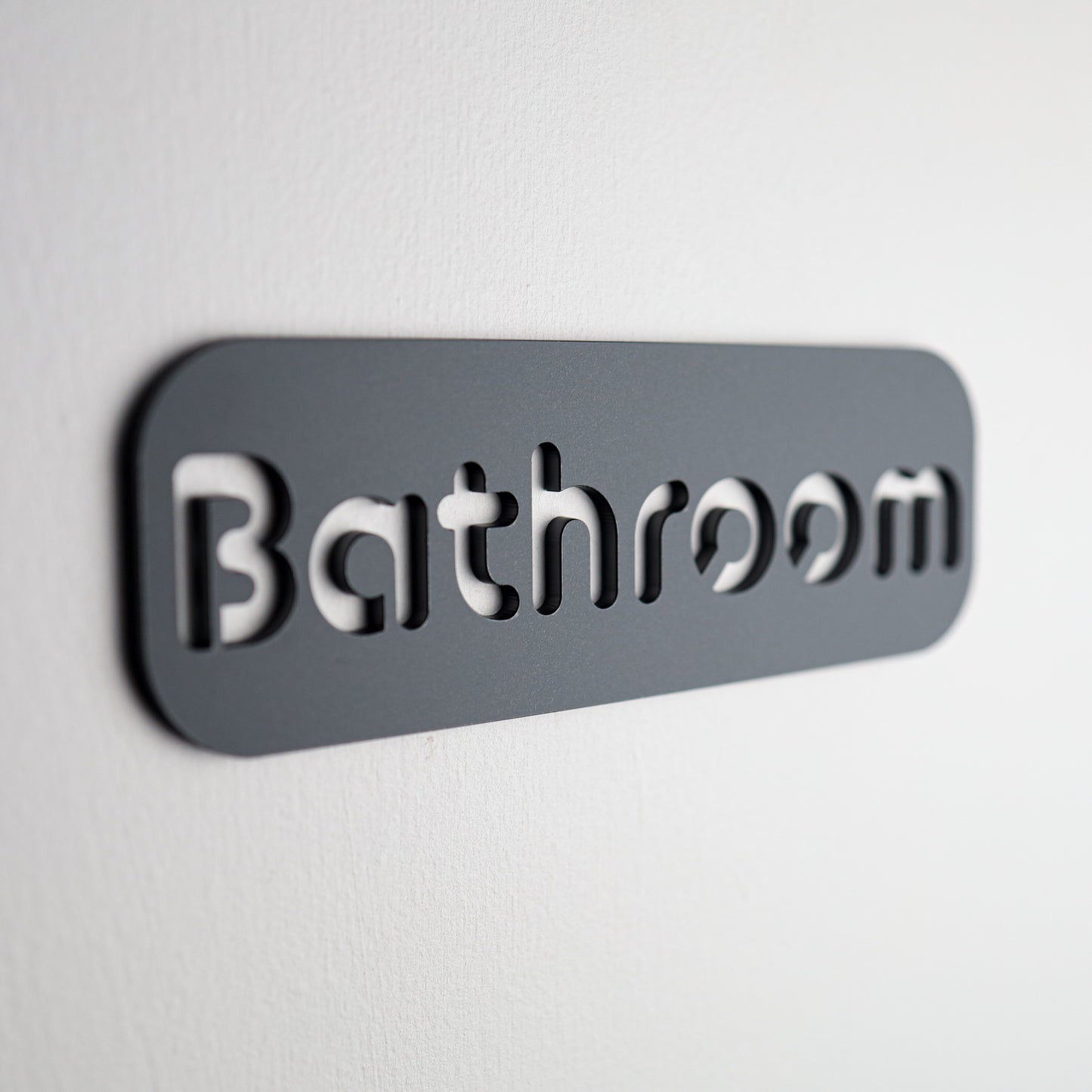 Stylish black "Bathroom" door sign with a stone texture finish and self-adhesive backing.