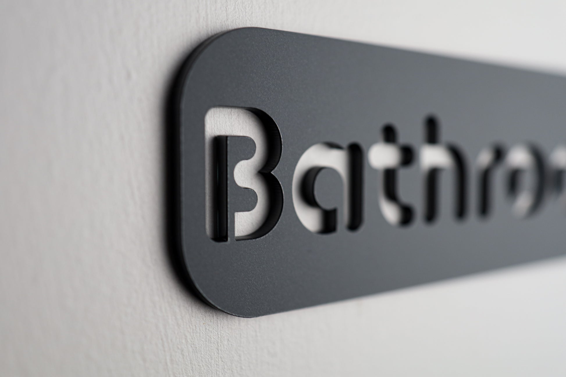 Contemporary bathroom sign made from durable black Stone Texture acrylic.