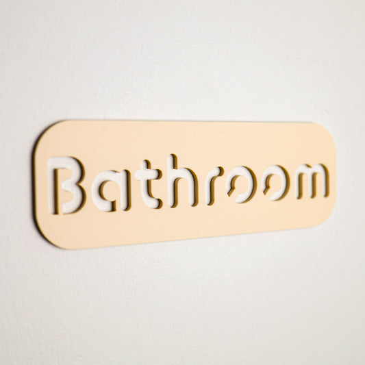 Sleek beige restroom sign with elegant cut-out lettering, ideal for high-moisture environments