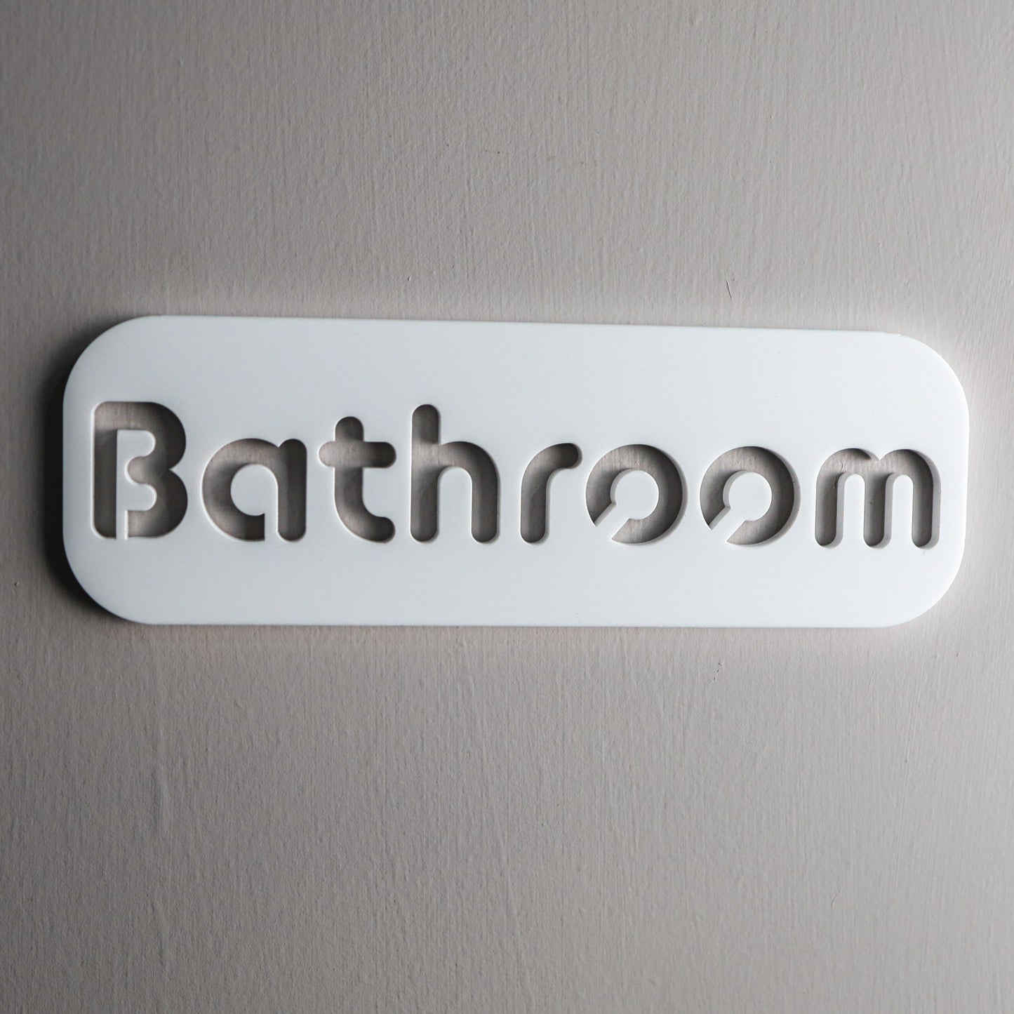 minimalist bathroom sign in black and white acrylic