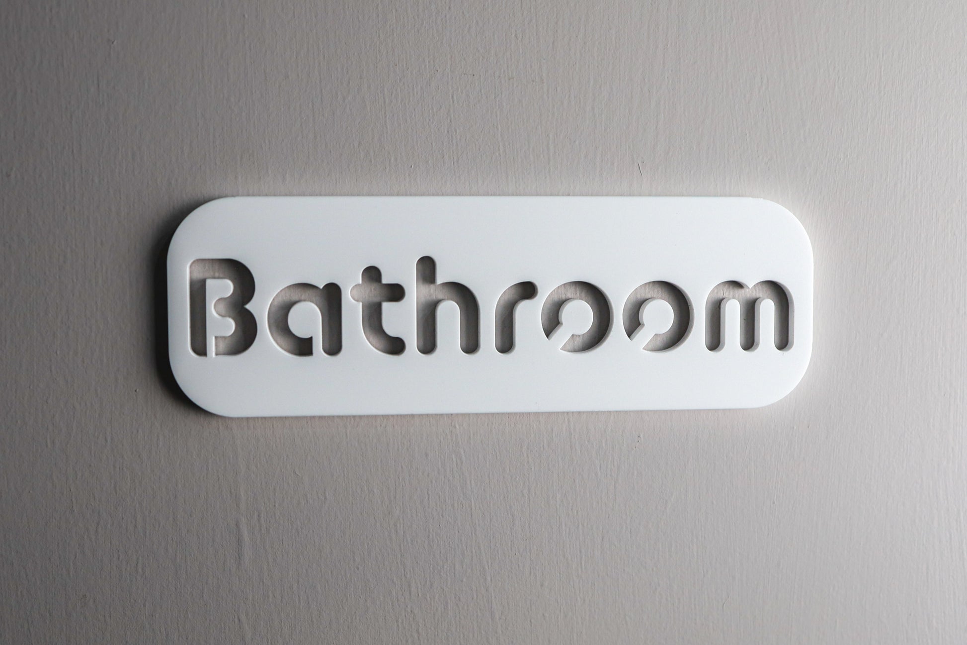 Modern restroom sign crafted from durable, waterproof acrylic with self-adhesive backing