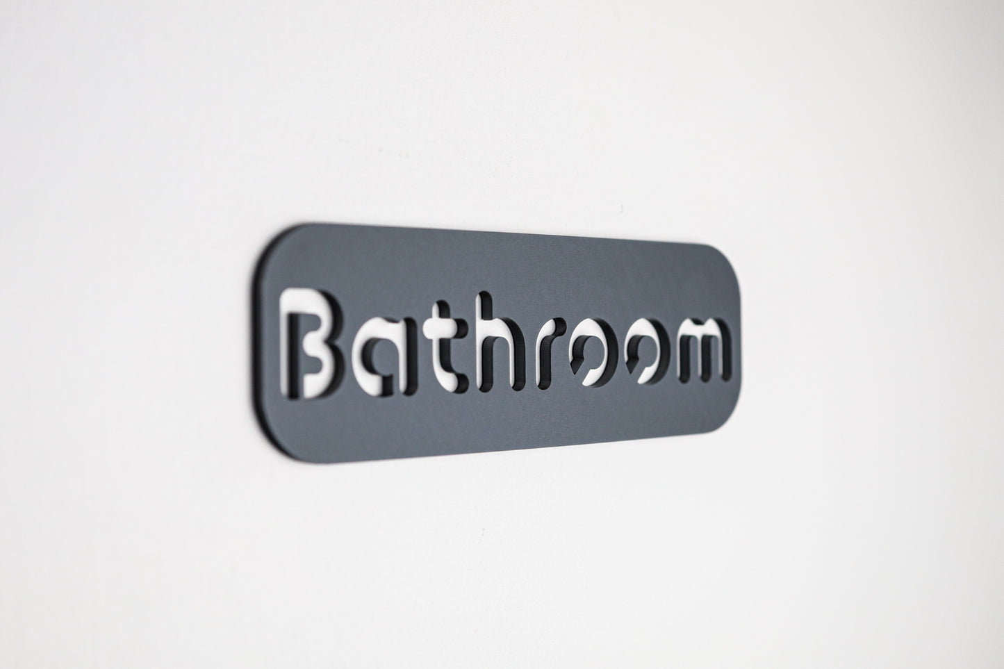 Contemporary bathroom sign with clean black lettering on grey stone texture acrylic