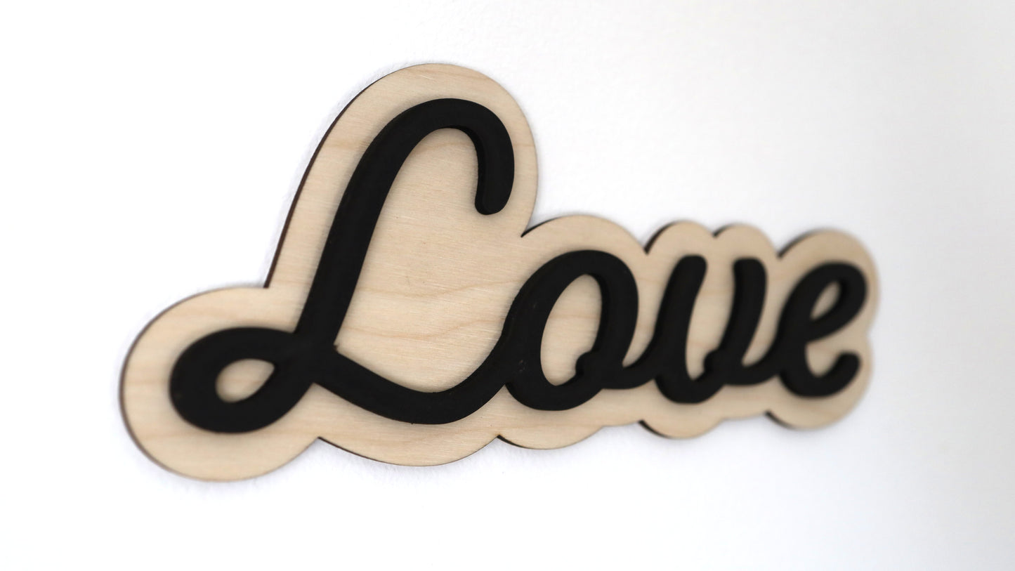 Close-up of birchwood 'Love' sign with black lettering